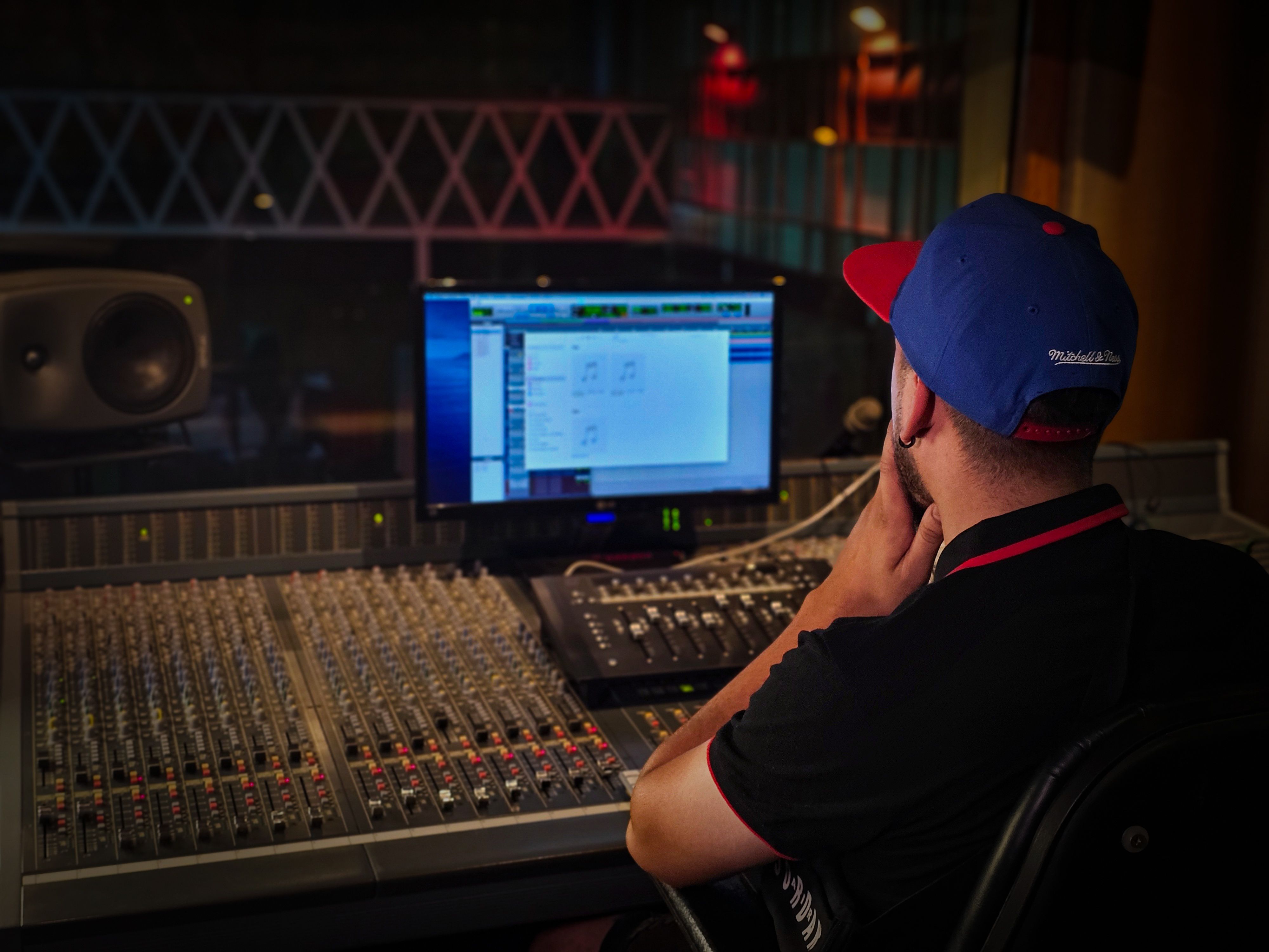 Audio engineer mixing at a console in a professional recording studio