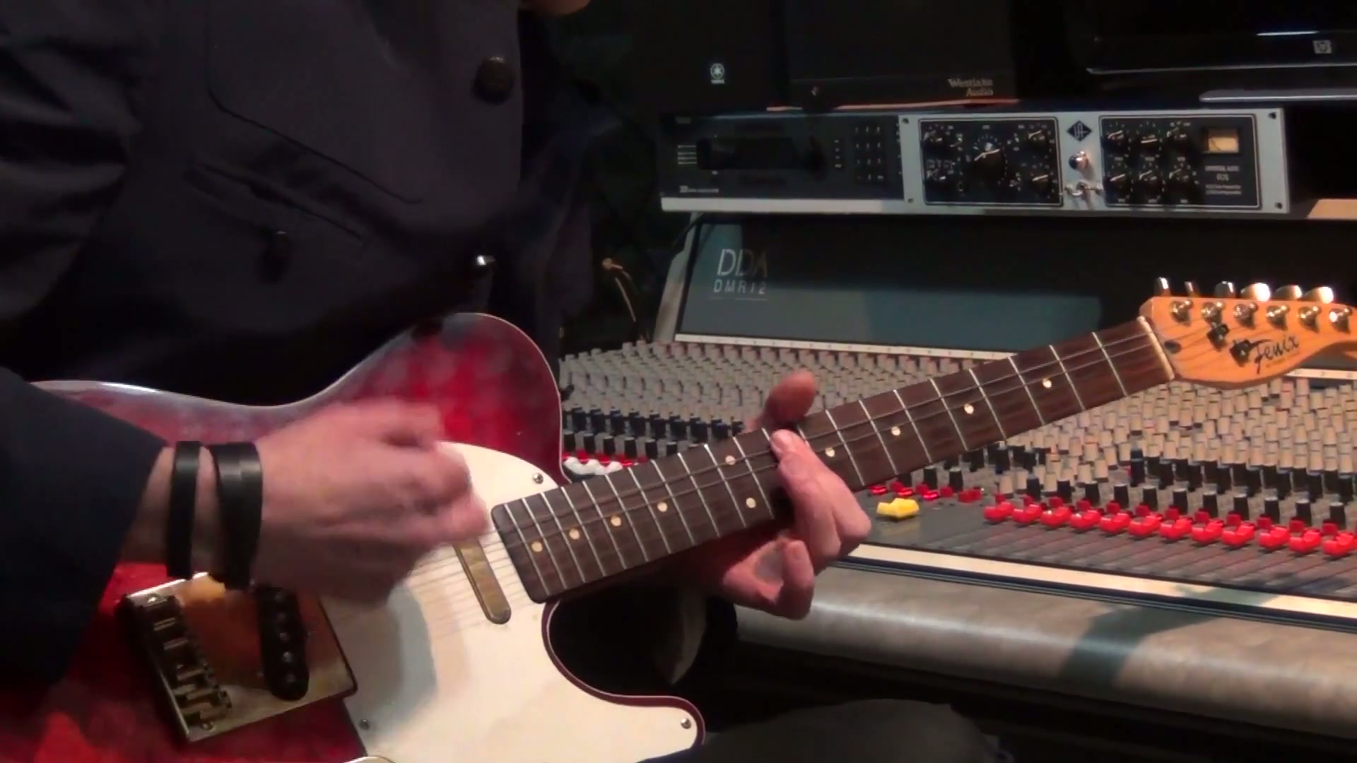 Guitarist playing an electric guitar in a recording studio